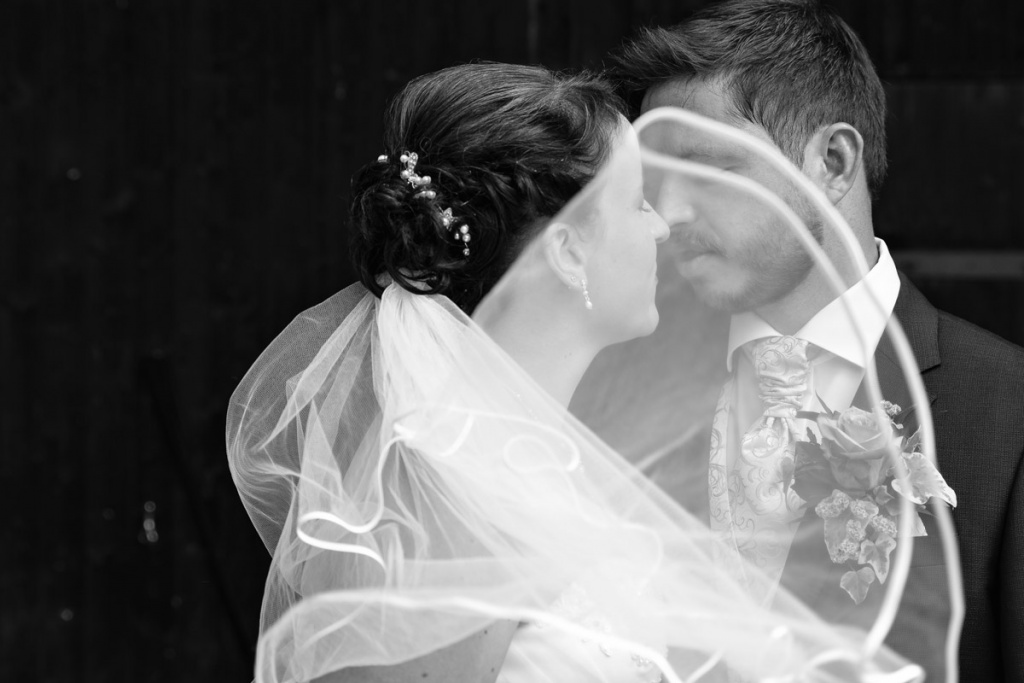 Porträt und Hochzeit, Hochzeitsfotografie eines Brautpaares mit wehendem Schleier