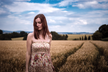 Porträt Fotografie: Girl In Summer Dress Stands On A Cornfield With Closed Eyes