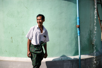 A Happy Man Is Standing In Front Of A Recently Inaugurated Water Tank In Myanmar